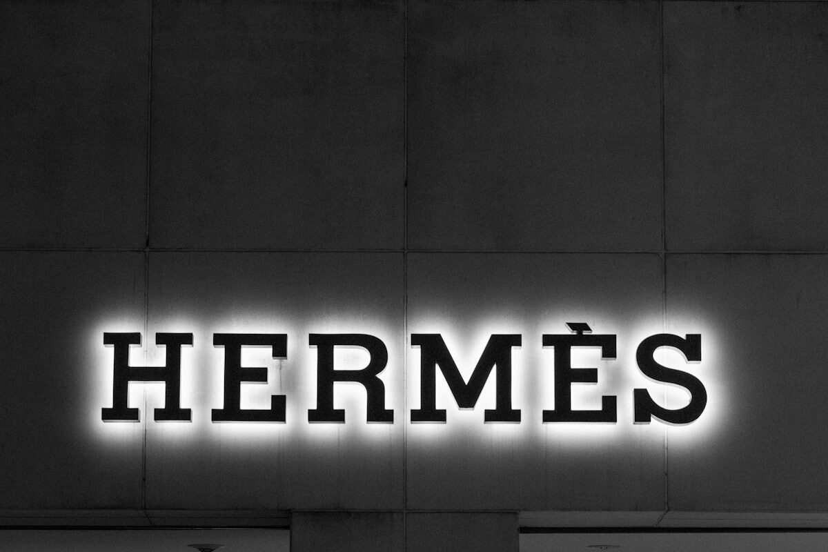 A black and white photo of a building with a neon sign