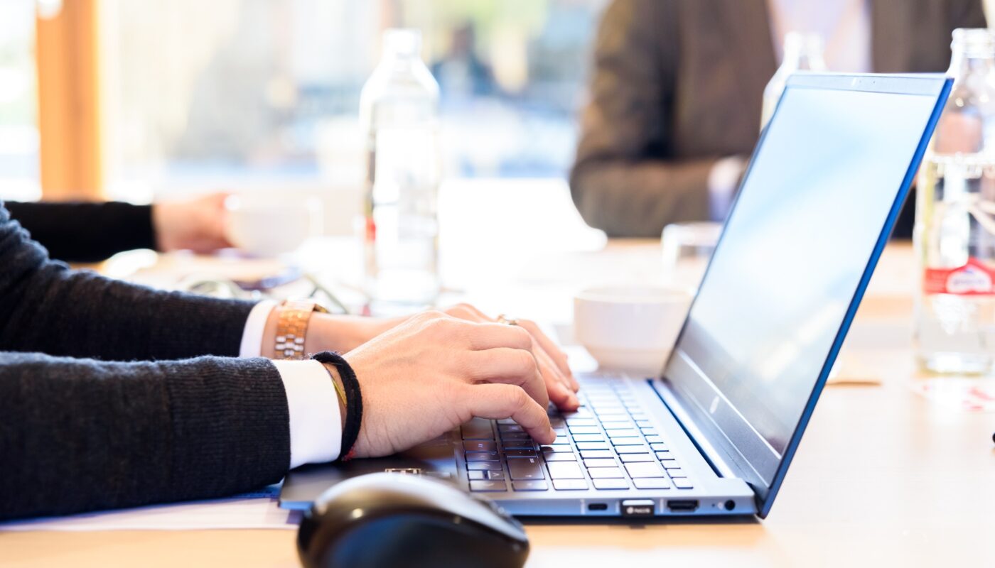 An enterprising employee types important information about her company on her laptop keyboard.