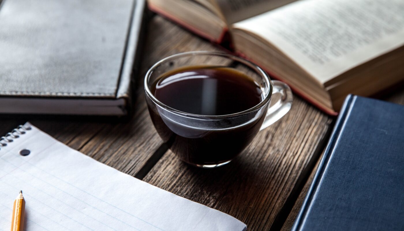 books and a cup of coffee on a wooden background