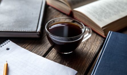 books and a cup of coffee on a wooden background